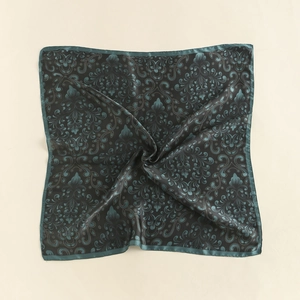 Detail of teal paisley pattern on smooth silk scarf with elegant satin finish