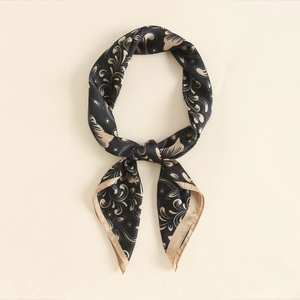 Close-up of silk square scarf featuring vintage paisley floral patterns and gold borders