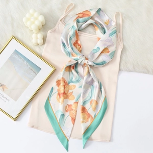 Close-up of floral print satin scarf tied as a necktie on a stylish camisole top