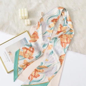 Elegant pink silk scarf with floral tulip print and mint green border on plush rug