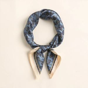 Close-up of grey-blue silk scarf with equestrian horse bit and rope patterns with gold borders
