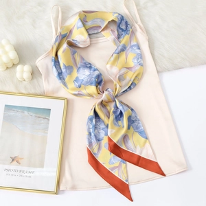 Elegant floral print satin silk twilly scarf tied on a camisole top on white desktop