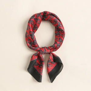 Detail of red and black silk scarf with equestrian stirrup and chain print patterns