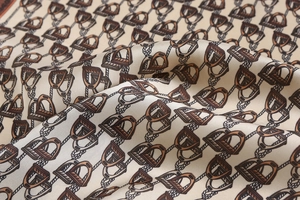 Close-up of silk square scarf featuring vintage horse stirrup and rope patterns