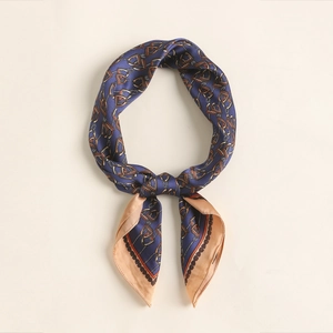 Close-up of navy silk scarf featuring gold equestrian bridle and stirrup patterns