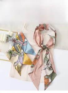 Detailansicht der floralen Seidenschals in Rosa, Blau und Gelb auf elegantem Satin