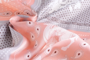 Close-up of vintage paisley silk scarf featuring elegant gold-toned edges and soft texture