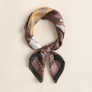 Detail of vintage silk scarf featuring paisley patterns and gold-edged floral borders
