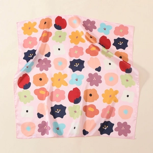 Detalle de un pañuelo de satén rosa con estampados florales vibrantes y textura de seda