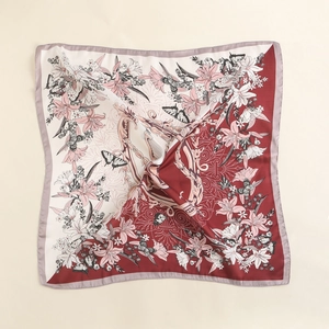 Close-up of retro square silk scarf with lily floral prints and butterfly patterns