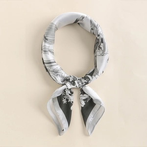 Macro detail of silk-like square scarf featuring elegant black and white floral patterns