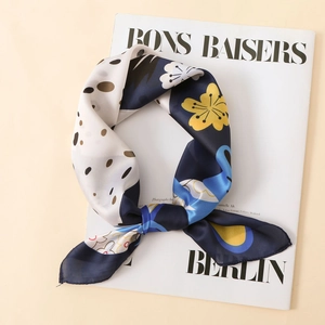 Foulard en soie bleu marine à fleurs et pois drapé sur un magazine de mode élégant