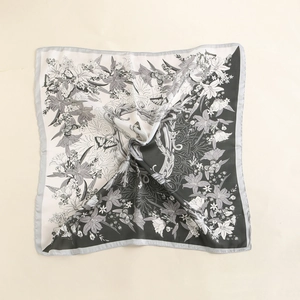 Detailed close-up of vintage silk-like square scarf with black and white lily floral print