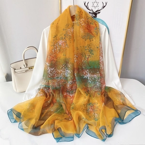 Détails macro d'une écharpe fleurie orange translucide drapée sur une chemise blanche