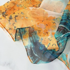 Vue détaillée de l'imprimé aquarelle abstrait et des bords roulés délicats d'un foulard
