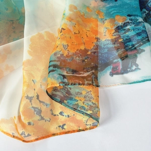 Gros plan d'un châle d'été léger avec un imprimé aquarelle bleu et orange artistique