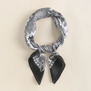 Detail of silk-like satin scarf featuring black and white paisley and floral patterns