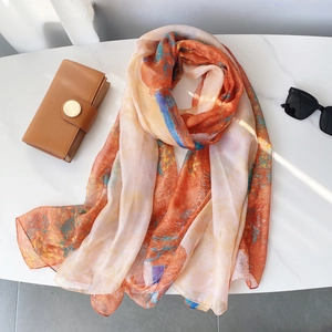 Détails de l'écharpe légère et transparente aux motifs abstraits orange et bleu vifs