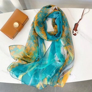 Détail d'un foulard en soie d'été doux avec des motifs floraux jaunes et bleus sur marbre