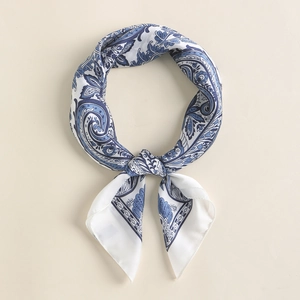 Detail of blue and white paisley silk square scarf tied in an elegant ring knot