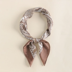 Detail of silk-like paisley scarf featuring vintage gold-toned edges and brown pattern