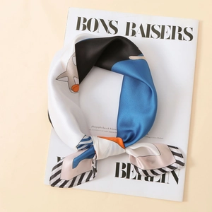 Détail d'un foulard carré en satin soyeux avec motifs de chats mignons et rayures chic