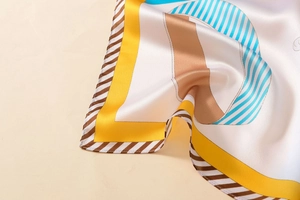 Gros plan d'un foulard en soie à motif géométrique montrant les bords et le satiné