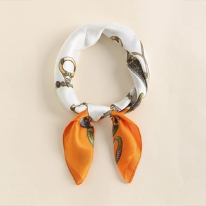 Close-up of orange silk scarf with luxury horse bit pattern tied in a ring