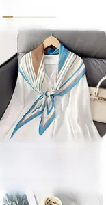 Detail of a diagonal striped rhombus silk scarf styled on a white long-sleeve shirt