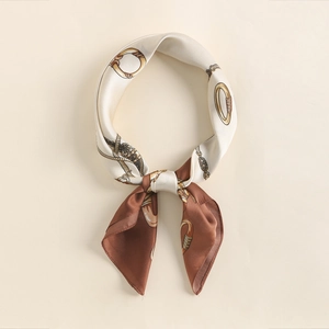 Close-up of retro silk square scarf with golden chain patterns and satin texture finish