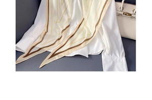 Close-up of geometric striped silk scarf paired with a white shirt and leather bag