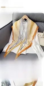 Detail eines Rauten-Seidentuchs mit markanten orange-schwarzen Streifen auf weißem Stoff