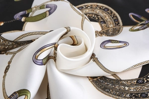 Close-up of silk square scarf featuring vintage equestrian chain patterns and gold edges