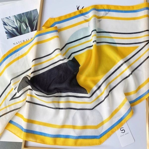 Close-up of semi-transparent geometric striped silk scarf with blue and yellow patterns