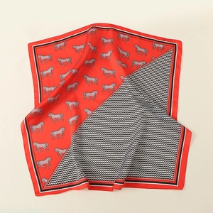 Detail of silk square scarf featuring red horse print and black chevron pattern