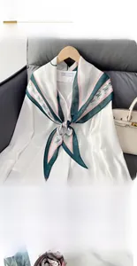 Detail of diamond-shaped silk scarf with H pattern tied on white shirt collar