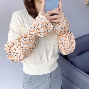 Detailed view of floral chiffon balloon sleeves and ribbed knit arm sleeves for women