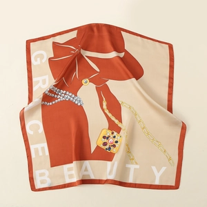 Detail view of silk-like square scarf featuring vintage jewelry prints and elegant draping