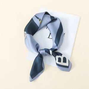 Detail shot of silk square scarf featuring letter B print and contrast gold borders