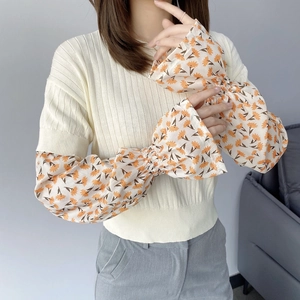 Detail of floral chiffon flared sleeves with daisy pattern on a knitted sun sleeve top