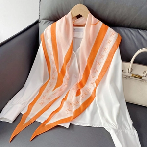 Elegant orange striped silk scarf with H pattern on white shirt with luxury handbag