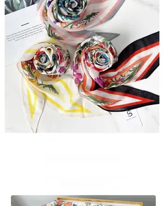 Détail de foulards en soie en forme de losange avec motifs floraux et rayures sur marbre