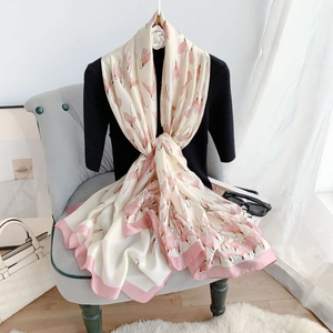Detailed view of floral silk scarf with pink borders draped on a vintage chair