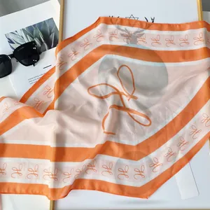 Detail of orange and white silk scarf with luxury H-letter print and fashion accessories
