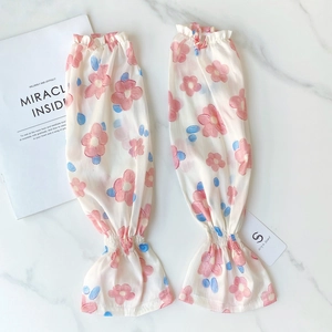Floral chiffon arm sleeves with elastic cuffs and pink flower pattern on white marble