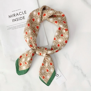 Detail of silk-feel square scarf with heart and star patterns and SIYA Scarf tag