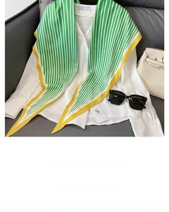 Detail of nautical blue and green striped silk scarf with yellow borders on a white shirt