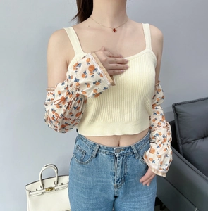 Detail of floral chiffon puff sleeves paired with a ribbed knit vest for sun protection
