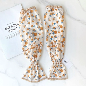 Detail of floral chiffon arm sleeves with orange roses and ruffled elastic cuffs