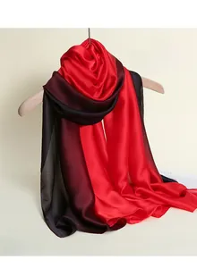 Detail of red and black gradient silk-satin scarf hanging on a wooden hanger